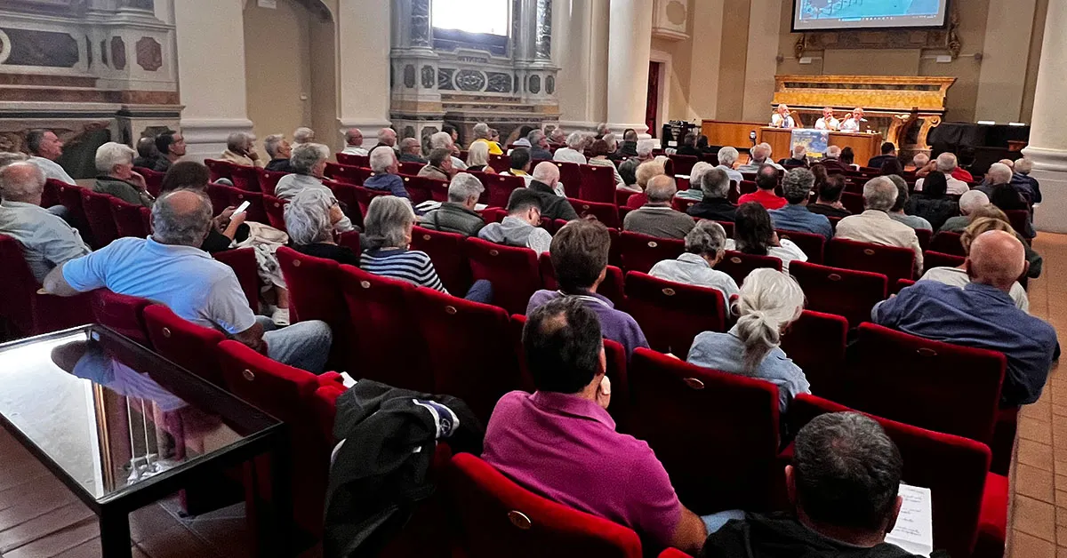 Il pubblico, inquadrato di spalle, mentre ascolta i relatori. IL luogo è l'Auditorium San Rocco, le poltrone sono quasi tutte occupate